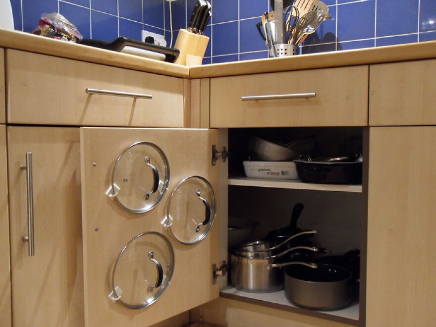 Kitchen cabinet with pots and pans neatly stored, demonstrating practical organization hacks for home storage.