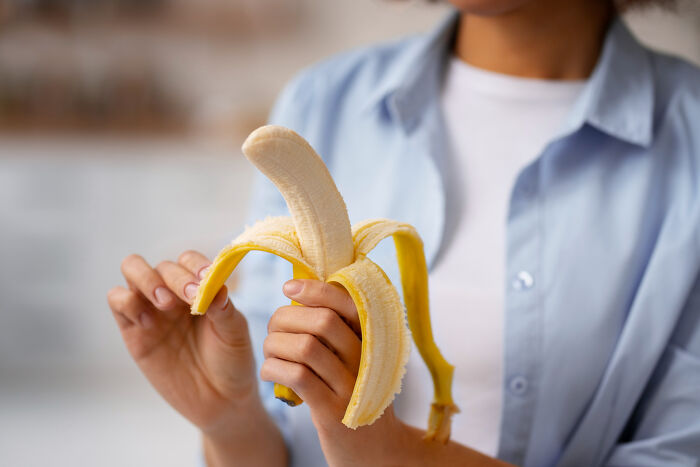 Person peeling a banana illustrating so-called genius life hacks that trick people into doing extra work.