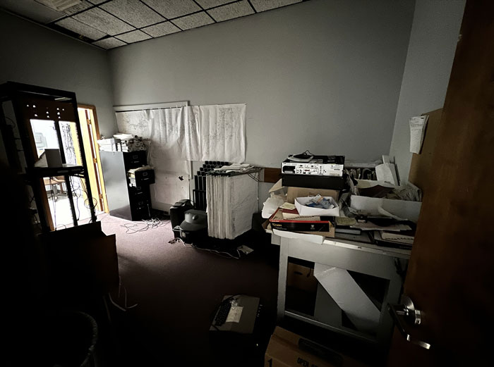 Cluttered office space covered in dust and grime with scattered papers and old equipment in a neglected workplace environment Cluttered office space covered in dust and grime with scattered papers and old equipment in a neglected workplace environment