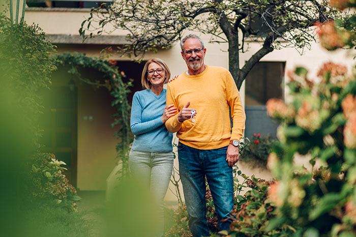 Middle-aged man and woman standing in garden, with man ready to turn on Karen mode against neighbors in block disputes. Middle-aged man and woman standing in garden, with man ready to turn on Karen mode against neighbors in block disputes.