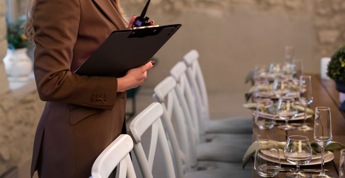 Event planner holding clipboard, inspecting elegant wedding table setup days before ceremony sabotage by parents.