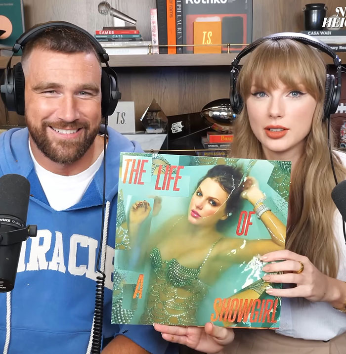 Travis Kelce and Taylor Swift fans react as he autographs her albums amid tradwife controversy in a podcast setting. Travis Kelce and Taylor Swift fans react as he autographs her albums amid tradwife controversy in a podcast setting.