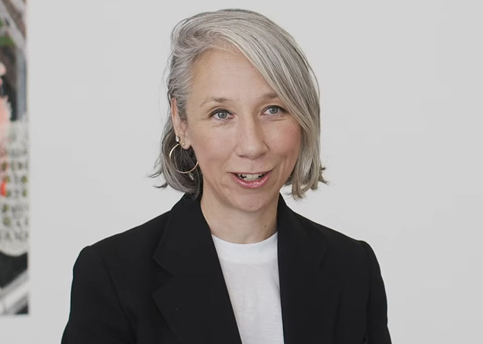 Woman with short gray hair wearing a black blazer and white shirt speaking about Keanu Reeves marriage rumors. Woman with short gray hair wearing a black blazer and white shirt speaking about Keanu Reeves marriage rumors.