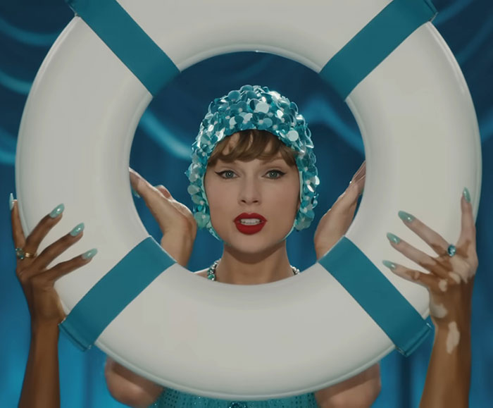 Taylor Swift in a shimmering swim cap holding a lifebuoy, hinting a secret jab at her ex in new music video. Taylor Swift in a shimmering swim cap holding a lifebuoy, hinting a secret jab at her ex in new music video.