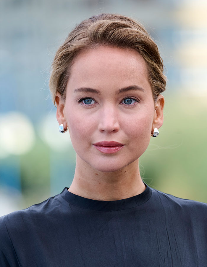 Jennifer Lawrence close-up portrait with natural makeup, earrings, and hair pulled back, addressing plastic surgery plans. Jennifer Lawrence close-up portrait with natural makeup, earrings, and hair pulled back, addressing plastic surgery plans.