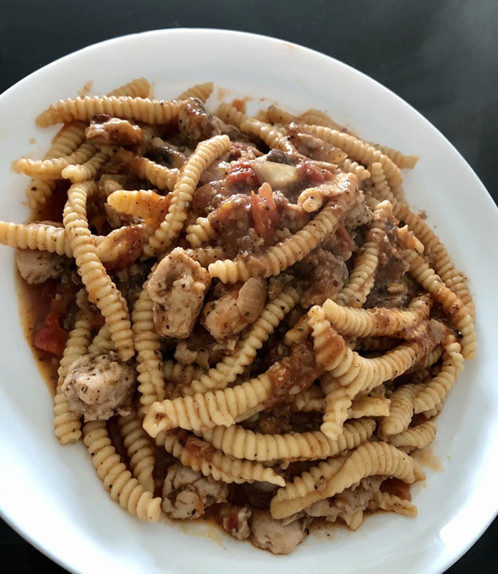 Plate of pasta with chunky sauce that looks unusual and unappetizing, fitting cursed and disgusting pictures of food theme
