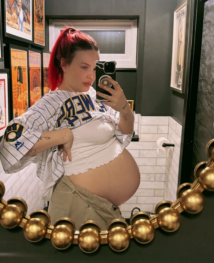 Pregnant pop star taking a mirror selfie in casual clothes, raising questions about diabetes and baby naming choices. Pregnant pop star taking a mirror selfie in casual clothes, raising questions about diabetes and baby naming choices.