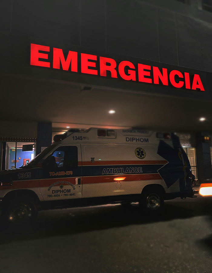 Emergency sign glowing red above ambulance parked outside hospital, symbolizing woman's act leaving boyfriend hospitalized. Emergency sign glowing red above ambulance parked outside hospital, symbolizing woman's act leaving boyfriend hospitalized.