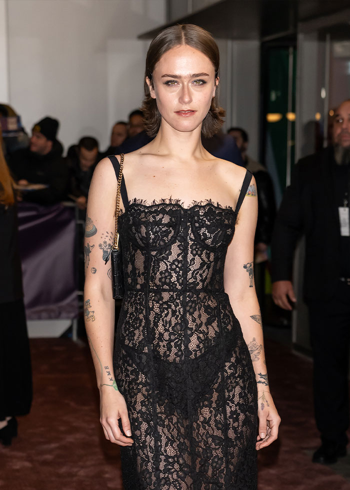 Woman wearing a daring black lace revealing dress at a red carpet event, highlighting the revealing dress trend. Woman wearing a daring black lace revealing dress at a red carpet event, highlighting the revealing dress trend.