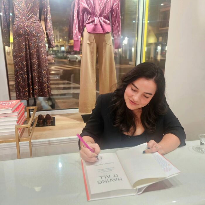 Female professor signing a book at a store, sparking debate after evidence-based decision to stop dating men. Female professor signing a book at a store, sparking debate after evidence-based decision to stop dating men.