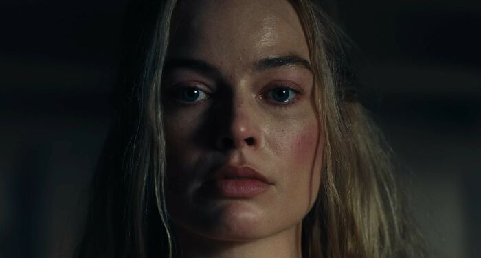 Close-up of Margot Robbie with a serious expression in the provocative Wuthering Heights trailer scene. Close-up of Margot Robbie with a serious expression in the provocative Wuthering Heights trailer scene.