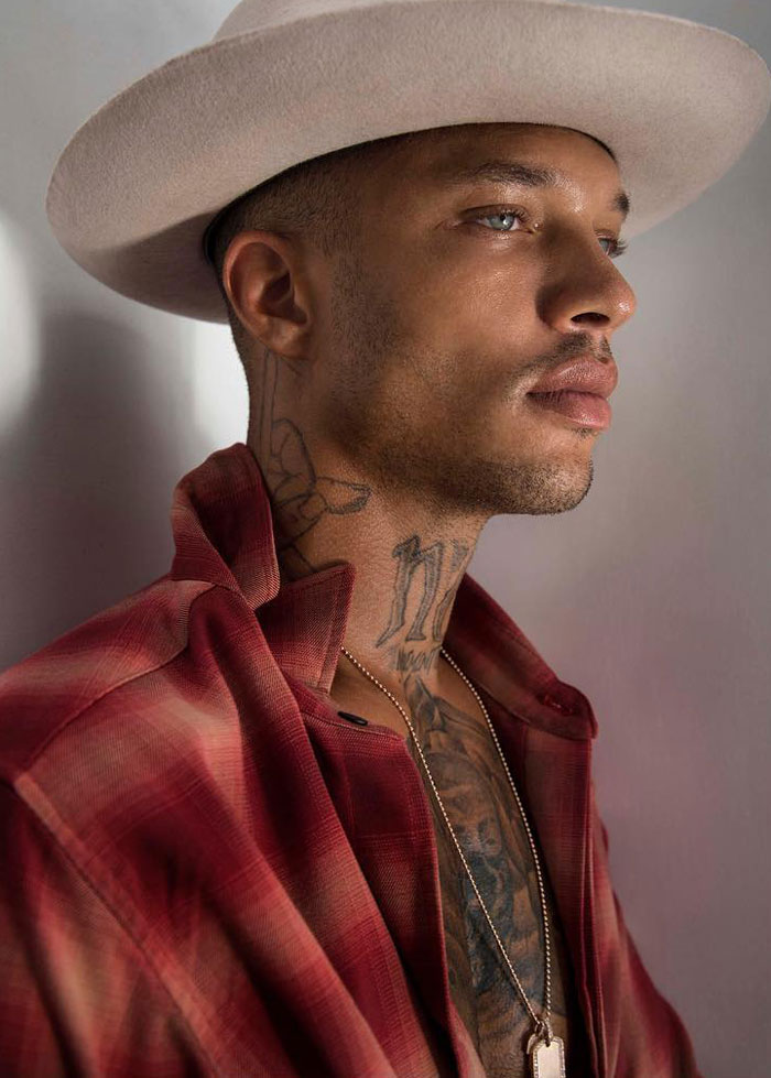 Man with tattoos wearing a beige hat and red shirt, showing the look of the world's hottest felon at 41 years old. Man with tattoos wearing a beige hat and red shirt, showing the look of the world's hottest felon at 41 years old.
