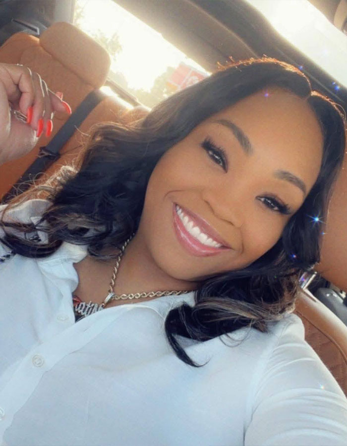 Young woman smiling inside a car, representing a woman's unhinged act after breaking into boyfriend’s home incident. Young woman smiling inside a car, representing a woman's unhinged act after breaking into boyfriend’s home incident.