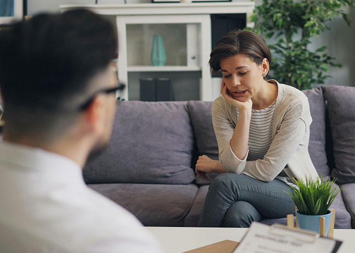 Woman consulting psychologist in a therapy session debunking common mental health myths in a comfortable office setting.