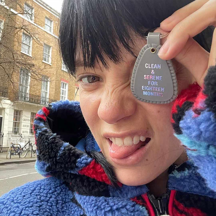 Lily Allen making a playful face outdoors, holding a keychain, highlighting new album and disturbing cheating claims. Lily Allen making a playful face outdoors, holding a keychain, highlighting new album and disturbing cheating claims.