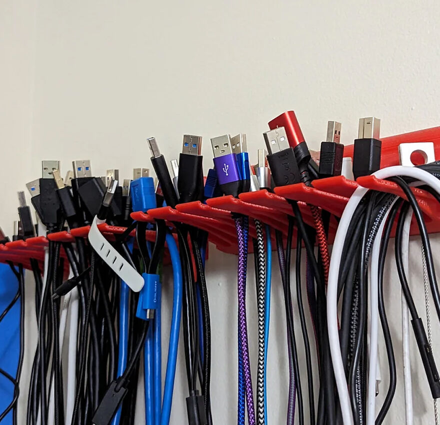 Organized USB and charging cables neatly held on red hooks showcasing effective organization hacks for home.