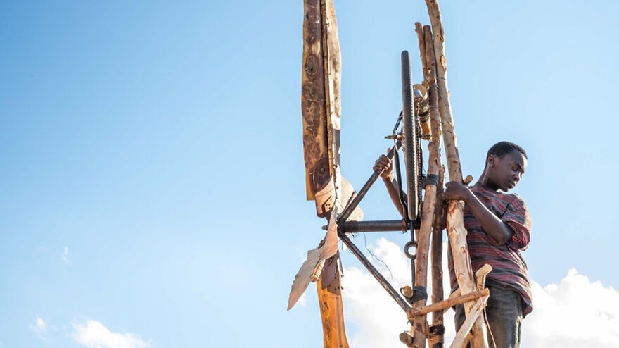 Young boy climbing a tall wooden structure in a scene from a movie based on true stories that feel impossible to believe.