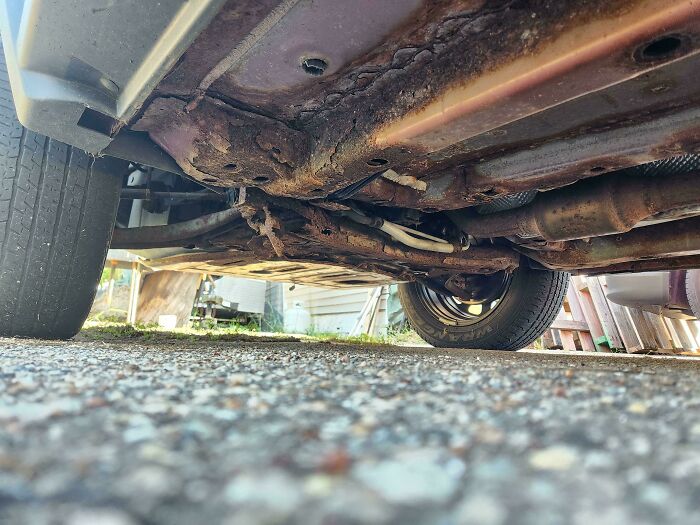 Rusty underside of an old car showing wear and damage, illustrating neglect in acting like sensible adults.