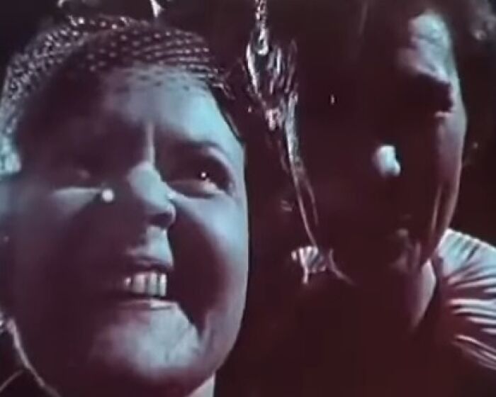 Two eerie figures in dim light with unsettling expressions, evoking creepy commercials and nightmare imagery.