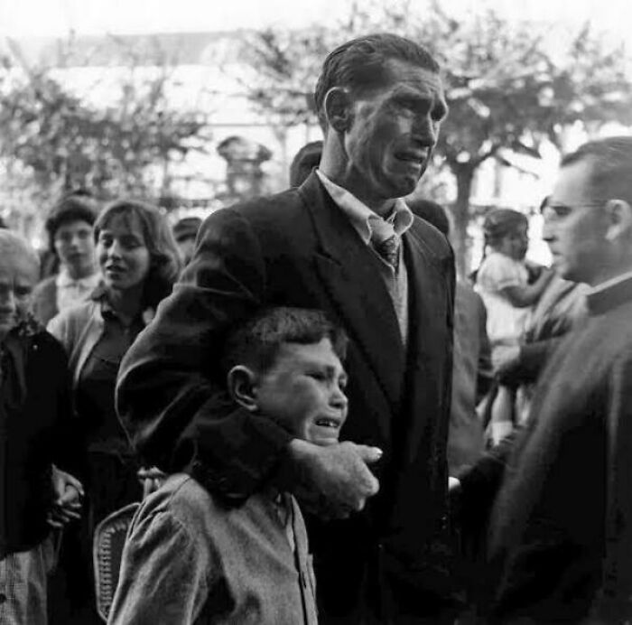 Black and white photo capturing emotional moment between man and crying child, highlighting fascinating photos that help see the world differently