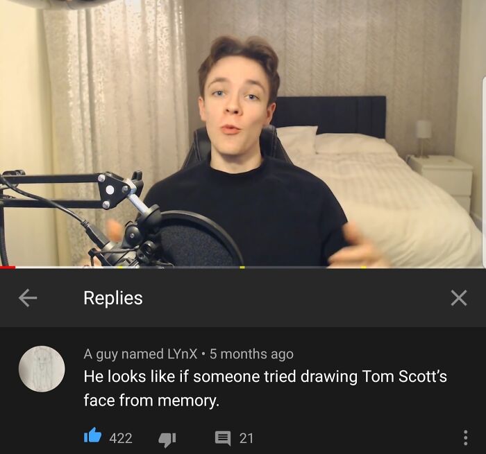 Young man in a black shirt recording a video with a microphone, showcasing hilarious YouTube comments in the background.