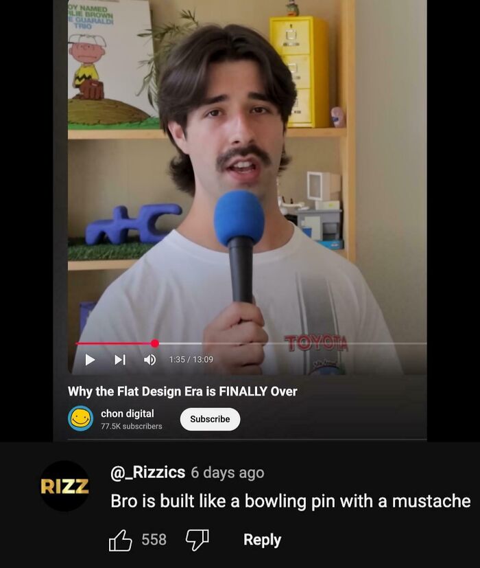Young man holding a blue microphone, with a humorous YouTube comment about a bowling pin mustache visible below the video.