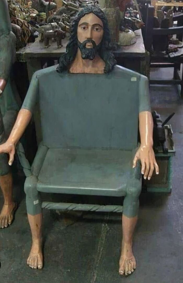 Wooden chair designed as a human figure with an occult-themed face, arms, and legs in an antique setting.