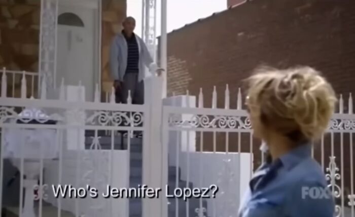 Man standing on porch asking who's Jennifer Lopez to woman at gate, capturing a funny and surprising oopsie moment.