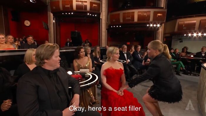 People at an awards ceremony reacting to a funny moment, showcasing memorable oopsies deserving hall of fame recognition