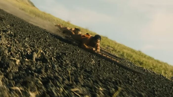 A person sliding headfirst down a steep dirt hill, illustrating dangerous and unsafe historical sports in action.