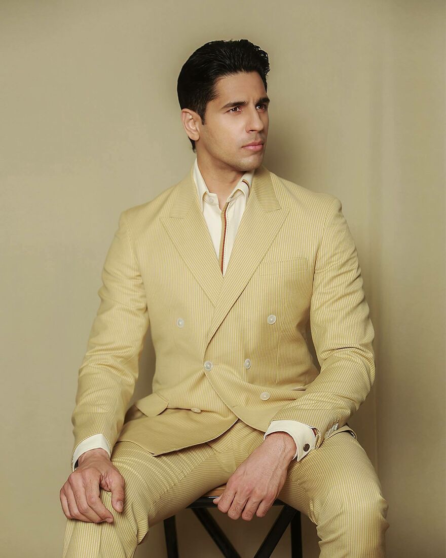 Sidharth Malhotra in a beige suit posing indoors, representing the handsome man in the world 2025 readers vote.