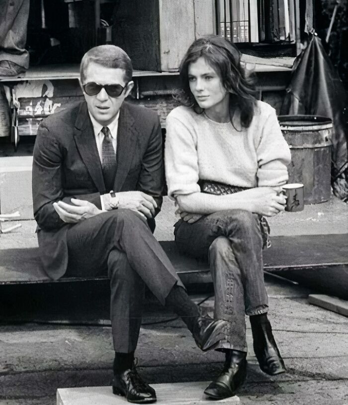 Black and white photo of two people sitting outdoors, representing iconic figures in movie and music industries. Black and white photo of two people sitting outdoors, representing iconic figures in movie and music industries.