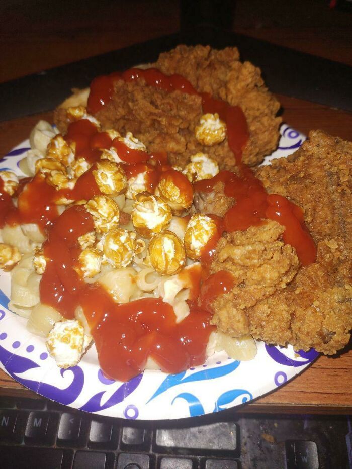 Plate of fried chicken, macaroni, popcorn, and ketchup combined in a cursed and disgusting food picture that might make you go eeeeew