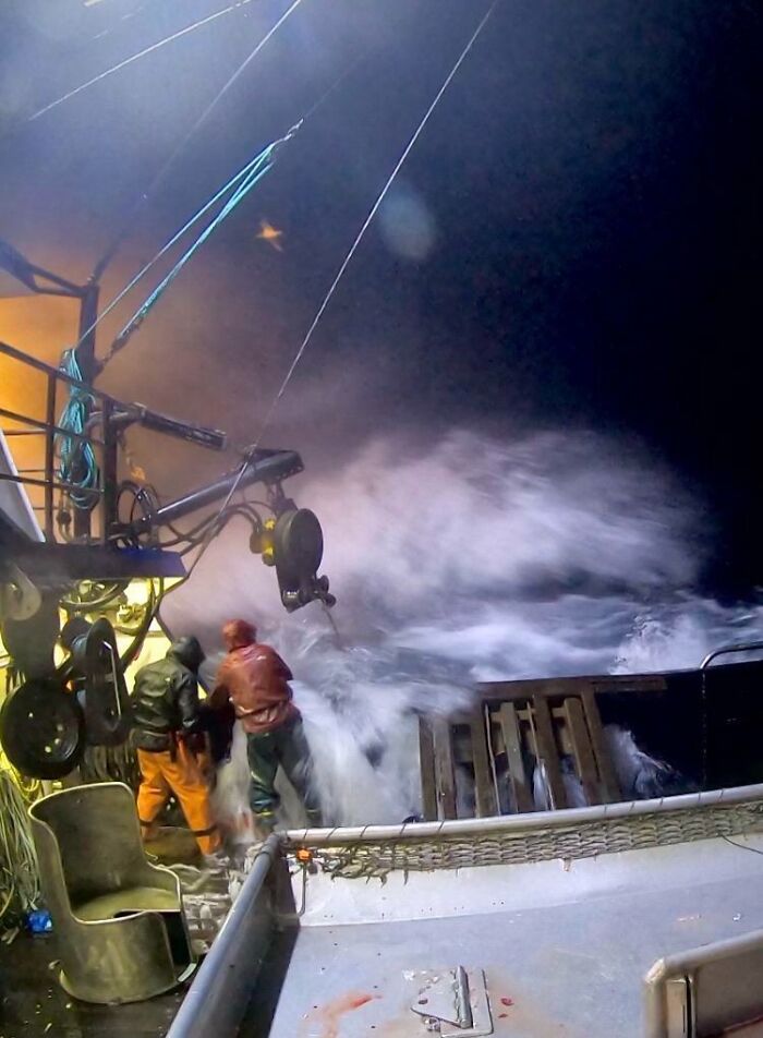 Fishermen battling rough seas at night on a fishing boat in a creepy and unsettling work environment.
