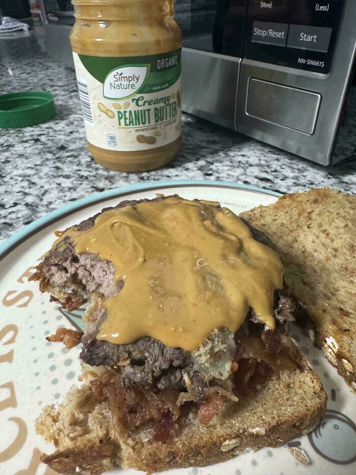 Open-faced sandwich with ground beef, bacon, and peanut butter on whole grain bread, a cursed and disgusting food combo.