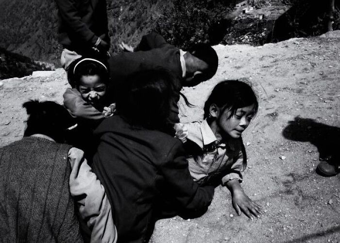 Black-and-white photo of children playing on a dusty street, capturing candid moments in the streets of India.