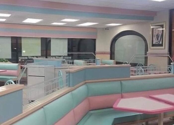 Empty diner with pastel booths and tables creating a beautiful yet unnerving liminal space atmosphere at night