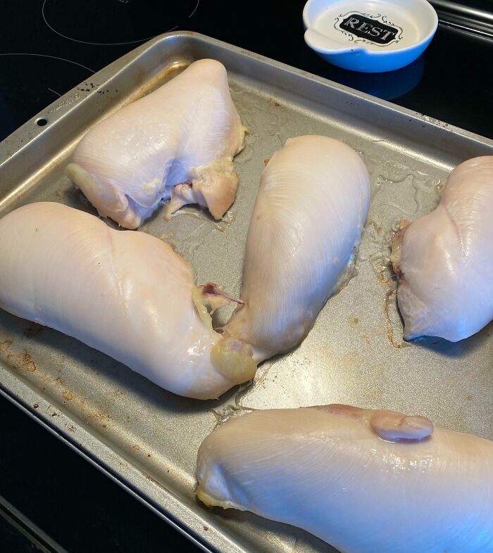 Raw chicken breasts on a baking tray, displaying a cursed and disgusting food picture that might make you go eeeeew.