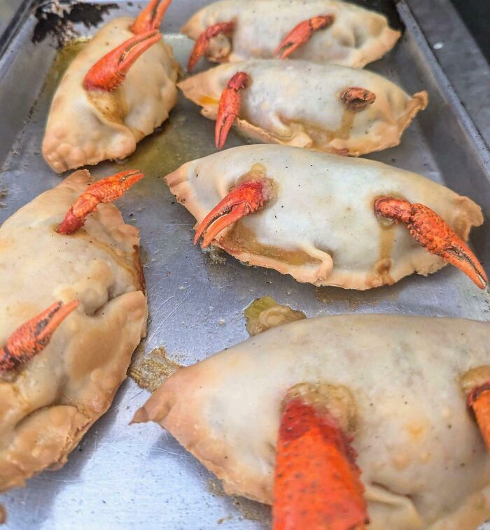 Baked food with crab claws sticking out, an unusual and cursed food presentation that might make you feel disgusted.