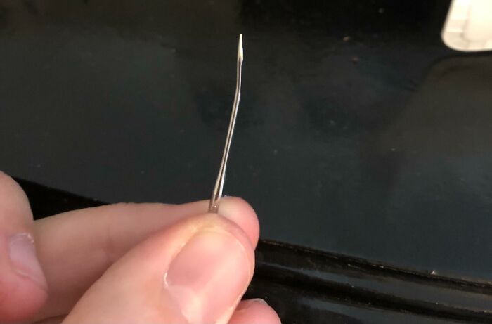 Close-up of a bent safety pin held between fingers, illustrating a simple Halloween fail from the spookiest day of the year.