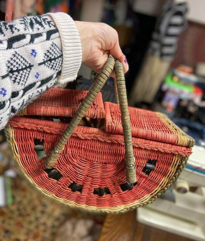 Hand holding a unique watermelon-shaped woven basket, a lucky thrift store shopper's vintage find.