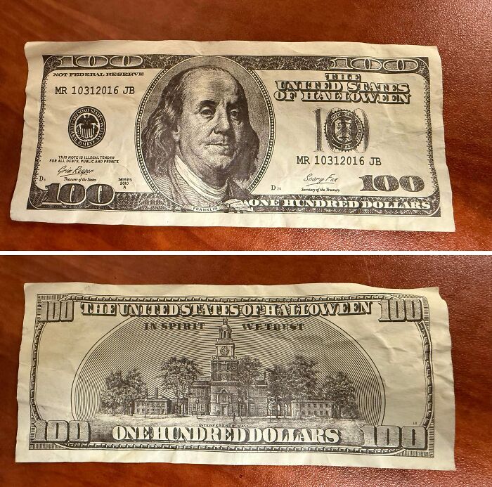 Fake Halloween-themed one hundred dollar bill with altered text showing a Halloween fail on a wooden surface.