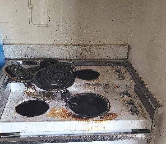 Old electric stove with broken and missing burners covered in rust and grime in a Halloween fails kitchen scene.