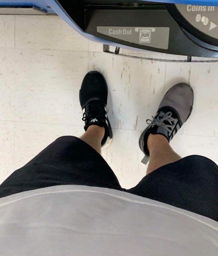 Mismatched black and gray shoes worn by person in black shorts, illustrating a Halloween fail mishap.