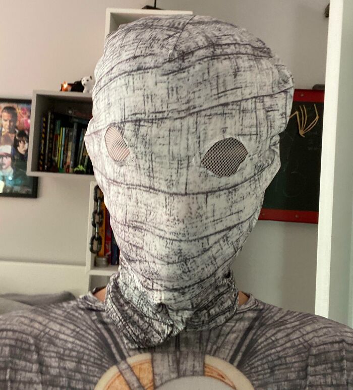 Person wearing a poorly designed mummy costume with misaligned eye holes causing a Halloween fail at home.