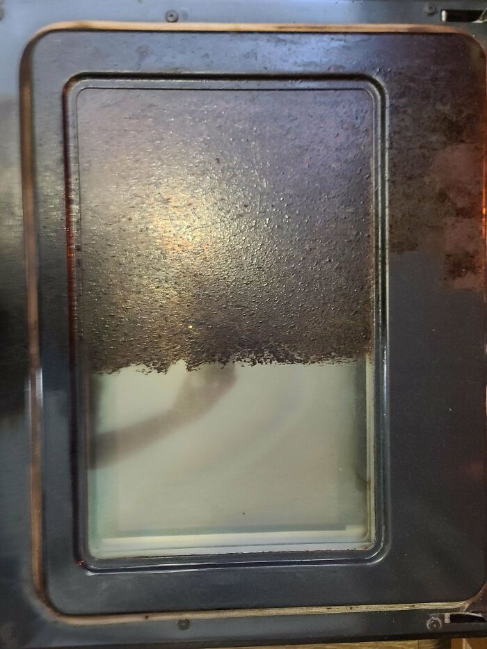 Before and after cleaning photo showing a heavily stained oven door glass cleaned to a clear finish.