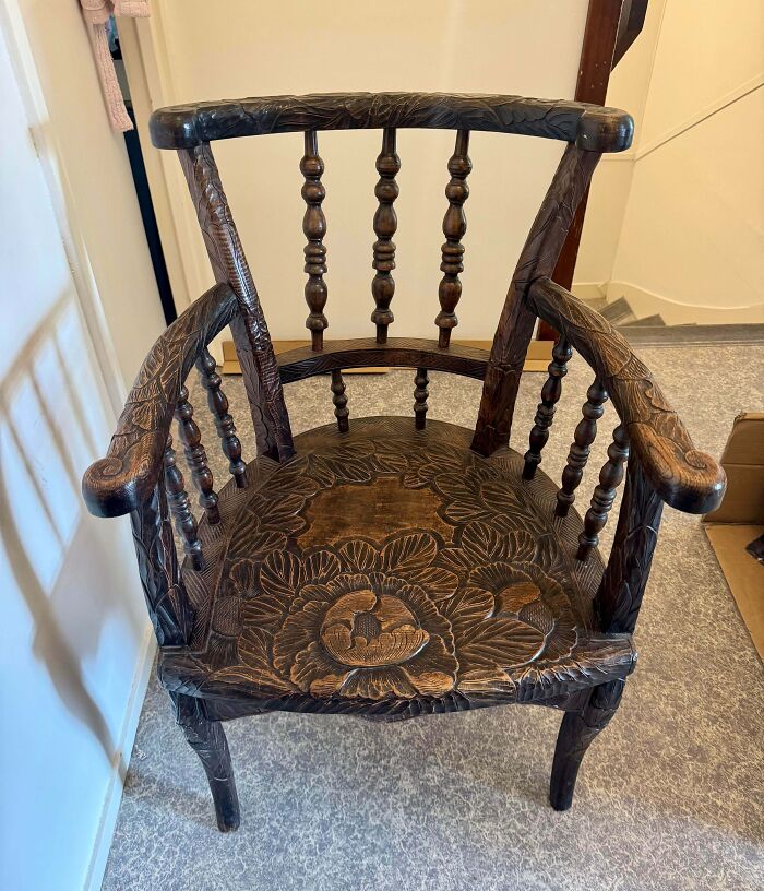 Carved wooden thrift store chair with floral patterns and spindle backrests, a lucky thrift store jackpot find.