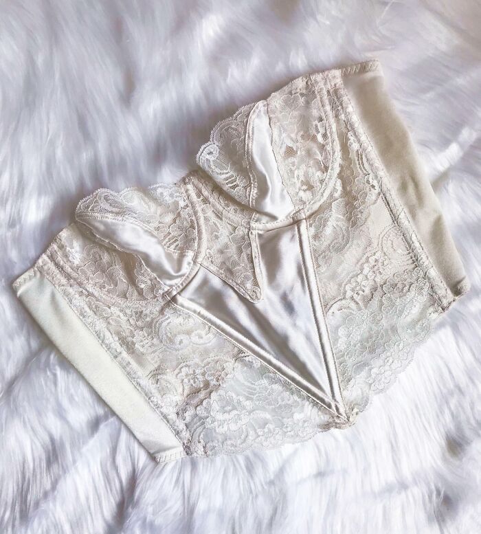 Lace and satin vintage lingerie piece folded on a soft white faux fur background, perfect thrift store jackpot find.