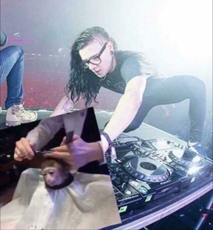 DJ wearing glasses and black shirt intensely mixing music on stage with a humorous cutout of a monkey getting a haircut nearby, pictures that go hard.