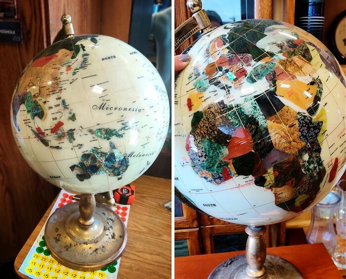 Vintage globe with decorative patchwork design on an antique metal stand found by lucky thrift store shoppers